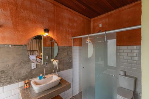 a bathroom with a sink and a shower and a mirror at Serra do Juá Pousada de Campo in Pirenópolis
