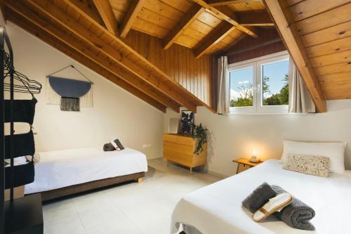 two beds in a room with wooden ceilings at The Hidden Attique in Corfu