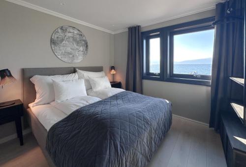 a bedroom with a bed with a view of the ocean at Lyngen Experience Lodge in Nord-Lenangen