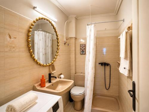 a bathroom with a sink toilet and a mirror at Virginia's Penthouse in Kassiopi