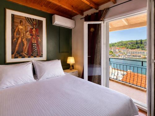 a bedroom with a large bed and a balcony at Virginia's Penthouse in Kassiopi