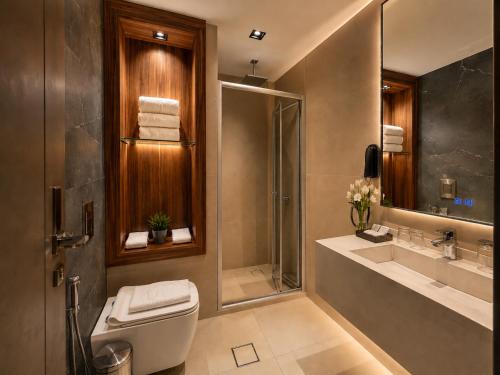a bathroom with a toilet and a shower and a sink at Coral Beach Hotel & Spa in Aqaba