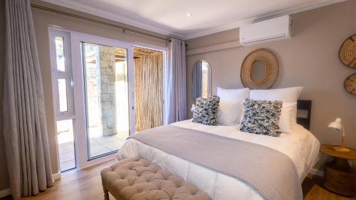 a bedroom with a bed and a large window at The Palm Suites in Meadowridge