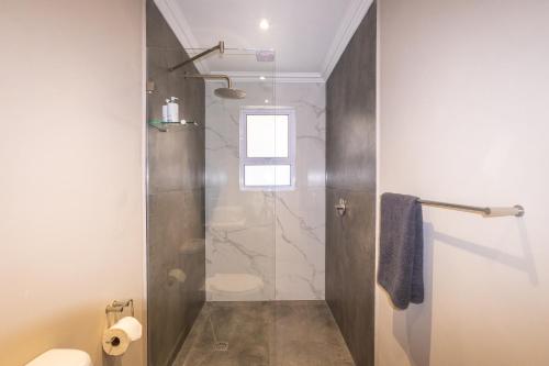 a bathroom with a shower with a toilet and a sink at The Palm Suites in Meadowridge