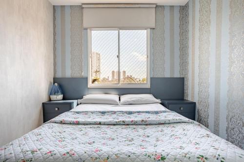 a bedroom with a large bed with a window at Apto com conforto que você precisa. in Goiânia