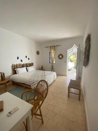 a bedroom with a bed and a table and chairs at ecrin mogador in Aït Sidi Saïd