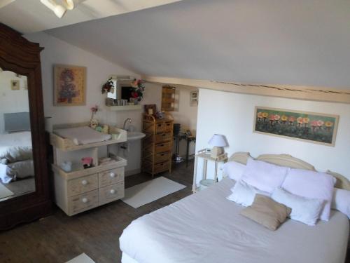 a bedroom with a white bed and a sink at Chez Julia in Puycelci