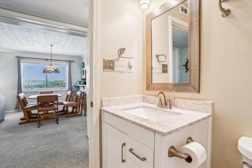 a bathroom with a sink and a mirror and a dining room at Duck Legacy Unit 2E in Duck