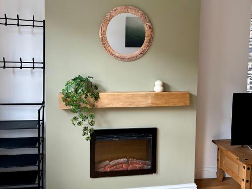 a living room with a fireplace and a mirror at Builth wells stay in Builth Wells