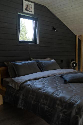 a bedroom with a large bed with a window at Horizon Славсько з чаном,басейном in Khashchovanoye