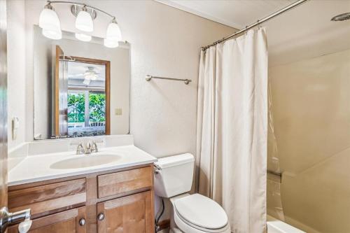 a bathroom with a toilet and a sink and a shower at Emerald Duck in Duck
