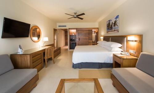 a hotel room with a bed and a tv at Occidental Punta Cana - All Inclusive in Punta Cana