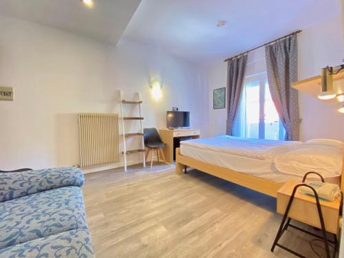 ein Schlafzimmer mit einem Bett, einem Schreibtisch und einem Stuhl in der Unterkunft Hotel Alberello - Varone in Riva del Garda
