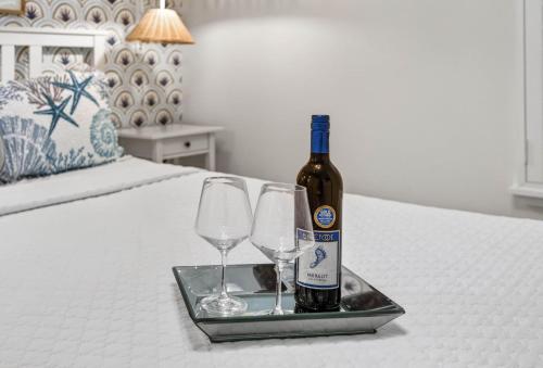 a bottle of wine and two glasses on a bed at Island Vibes House in Clearwater Beach
