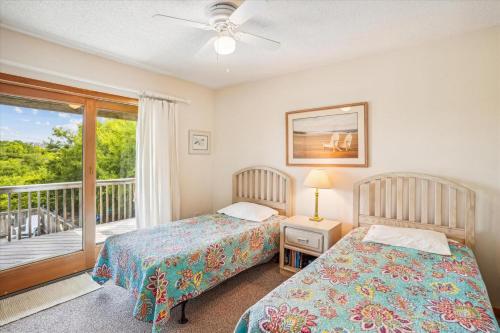 two beds in a bedroom with a balcony at Duck Views in Duck