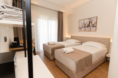 a hotel room with two beds and a couch at JB Hotel in Sarandë