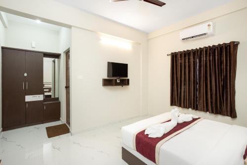 a hotel room with a bed and a tv at Hotel Livora in Alwaye