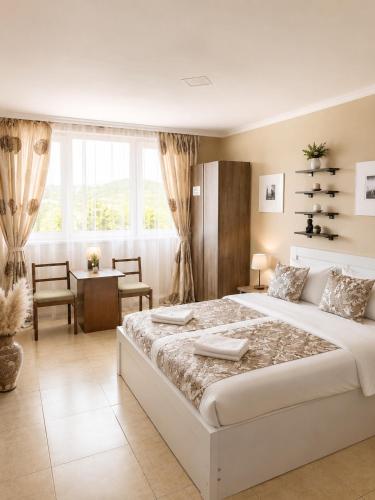 a bedroom with a large white bed and a desk at Aloft House in Kutaisi