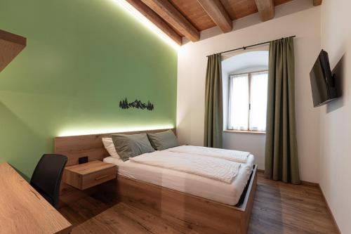 a small bedroom with a bed and a window at Palazzo Tamanini in Calceranica al Lago