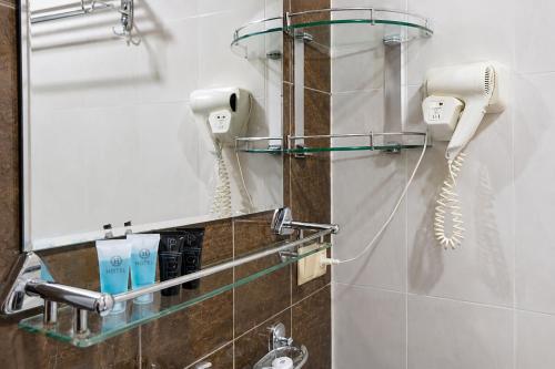 a bathroom with two phones hanging on a wall at Hotel Old Seti in Mestia