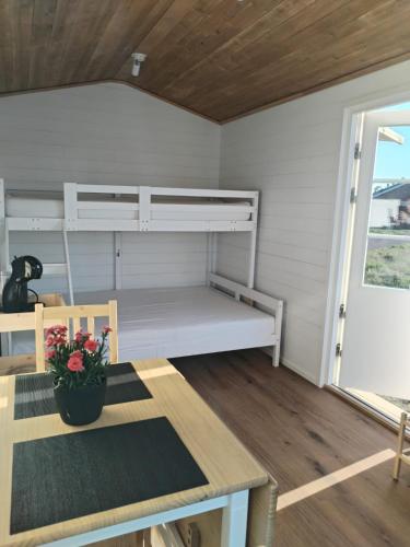 a room with a bunk bed and a table at Your cottege by the sea in Saltvik