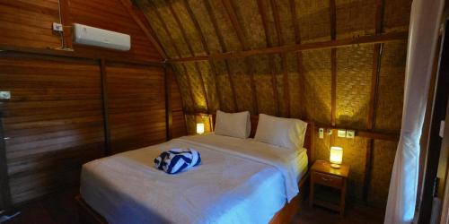 a bedroom with a bed in a wooden room at Bilva Garden Penida in Polilit