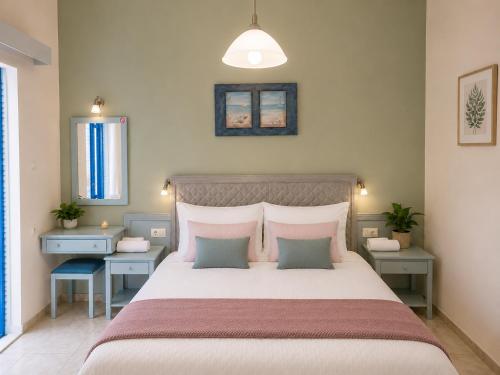 a bedroom with a large bed with pink pillows at Klima Rooms in Palaiochora