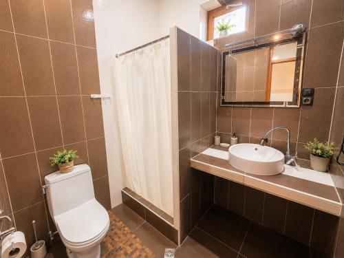 a bathroom with a toilet and a sink and a mirror at Aloft House in Kutaisi