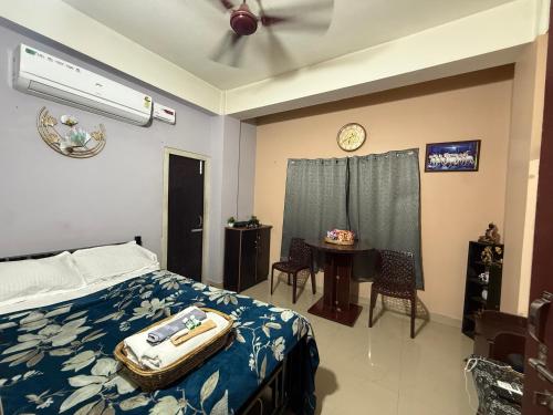 a bedroom with a bed and a table with chairs at Triveni Stays in Jorhat