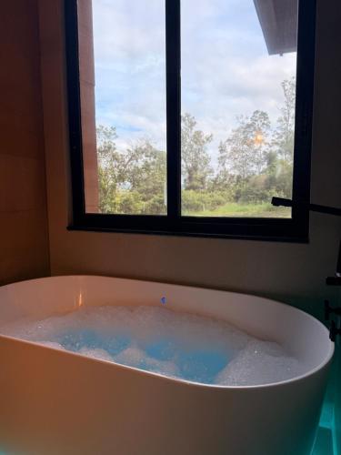 a bath tub in a bathroom with a window at Pousada Recanto das Rosas in Bragança Paulista