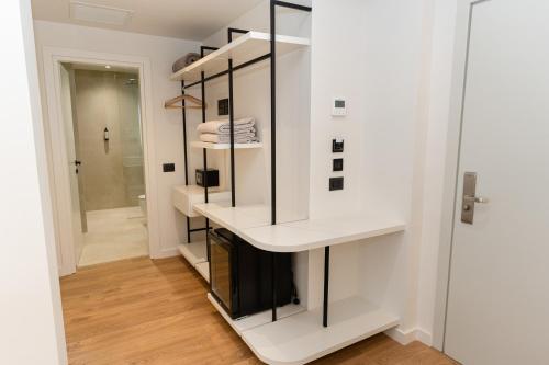 a room with white walls and glass shelves at JB Hotel in Sarandë