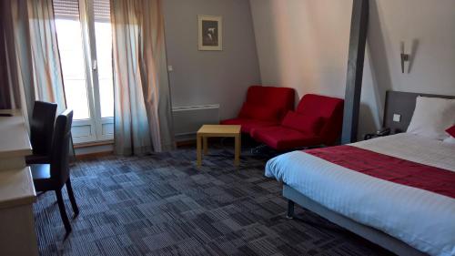 a hotel room with a bed and a red chair at Cour Du Tonnelier in Bouxwiller