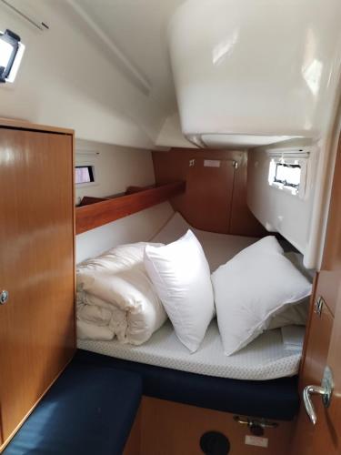 a bed with white pillows on a boat at Spend a night on a Sailing Boat in Saltvik