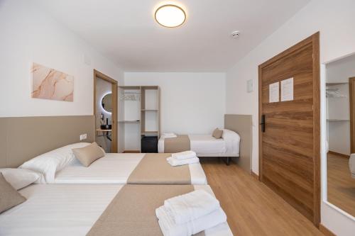 a hotel room with two beds and a door at La Posada Boutique rooms Albir in Albir