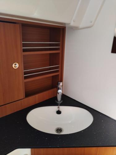 a bathroom with a white sink in a room at Spend a night on a Sailing Boat in Saltvik