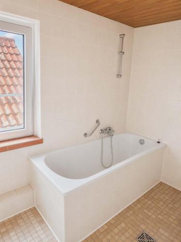 a white bath tub in a bathroom with a window at Hotel Ochsen in Leonberg