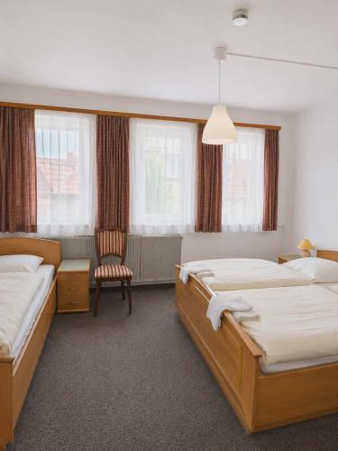 a hotel room with two beds and a chair at Hotel Ochsen in Leonberg