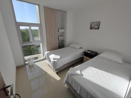 a hotel room with two beds and a window at Vista Urbana Atlantis in Santa Cruz de la Sierra