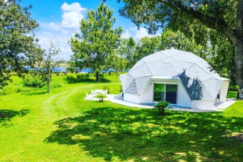 a white dome house in a field with trees at ROOM 03 - Lake Sumner in Clermont