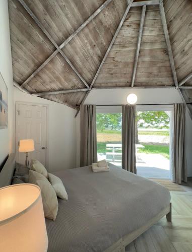 a bedroom with a bed and a large window at ROOM 04 - Lake Sumner in Clermont