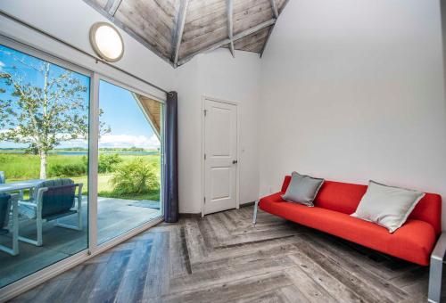 a living room with a red couch and a sliding glass door at STUDIO 01 - Lake Sumner in Clermont