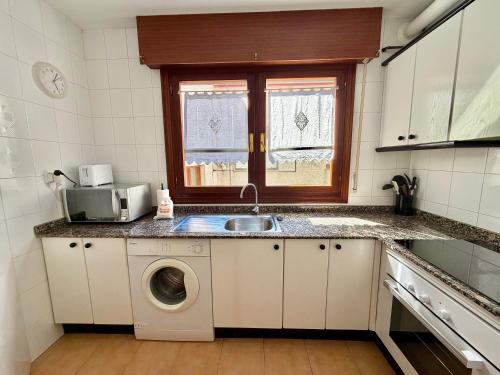 a kitchen with a sink and a washing machine at La Cometa de Ajo -12016 in Ajo