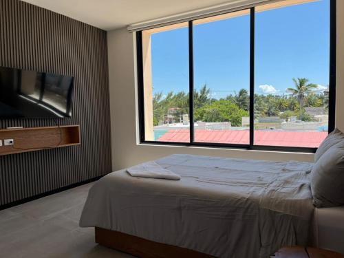 a bedroom with a bed and a large window at Oceanfront Paradise Family Friendly in Telchac Puerto