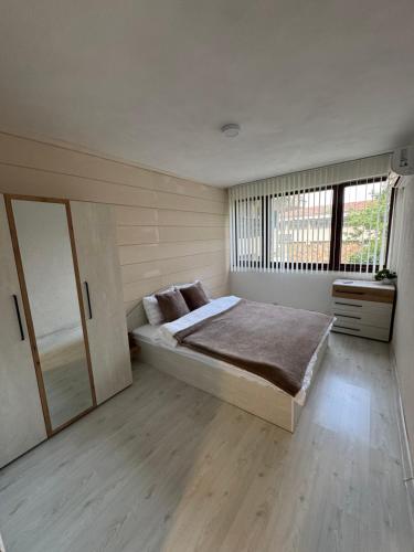a bedroom with a bed and a large window at Хижа Оборище in Oborishte