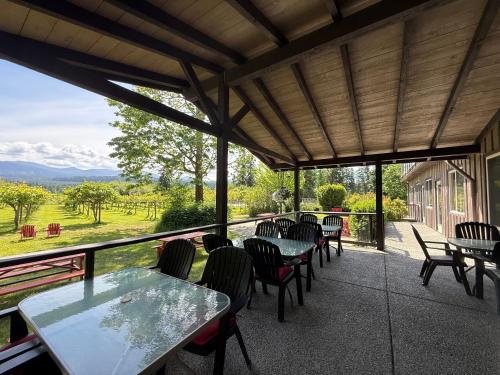 a patio with tables and chairs and a view at Kiwi Cove Lodge in Ladysmith