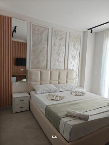 a bedroom with a large white bed with a large window at SeaView Vacation Rooms in Durrës