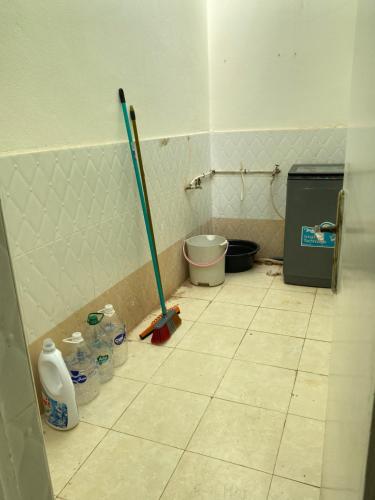 a bathroom with a tiled floor with a mop at Cozy Flat in Tan-Tan in Tan-Tan