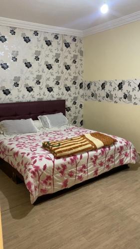a bedroom with a bed with a floral bedspread at Cozy Flat in Tan-Tan in Tan-Tan