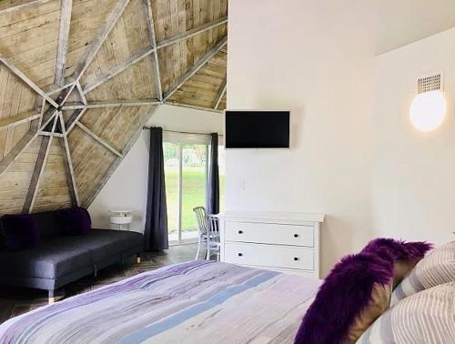 a bedroom with a large bed and a couch at STUDIO 02 - Lake Sumner in Clermont