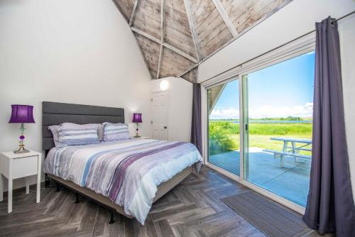 a bedroom with a bed and a large window at STUDIO 02 - Lake Sumner in Clermont